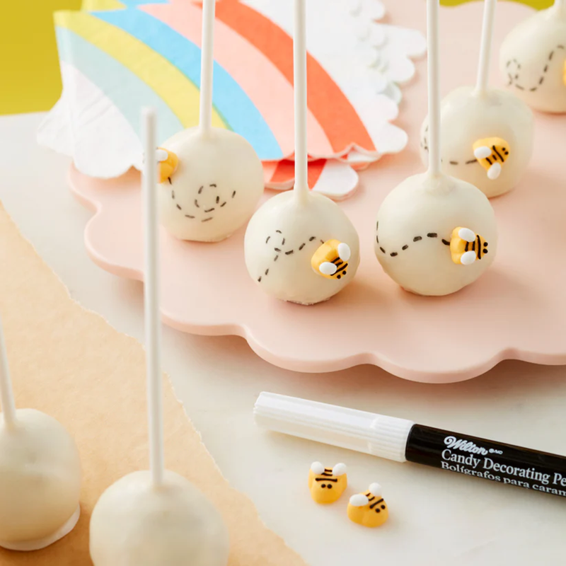 Example of use, White cake pops adorned with buzzing buzzy bees, bee flight path drawn on with a Black Candy Decorating Pen. 