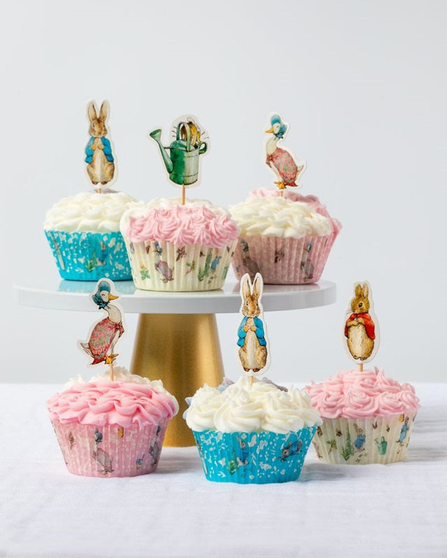 Example of 6 cupcakes displayed on a cake stand, using the cute Peter Rabbit cupcake papers (sold separately), piped with pink and white buttercream, adorned with Peter Rabbit and friends Character cupcake picks.